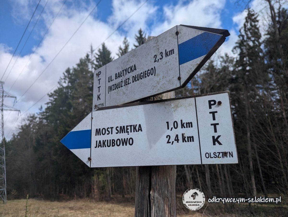 PTTK signpost by Lake Długie: ul. Bałtycka 2.3 km, Most Smętka 1.0 km, Jakubowo 2.4 km