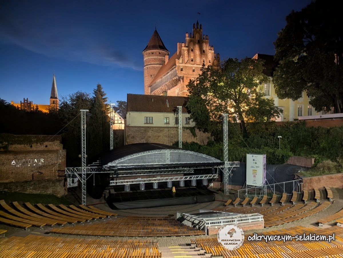The Castle of the Warmian Chapter and the amphitheatre with its roofed stage at dusk