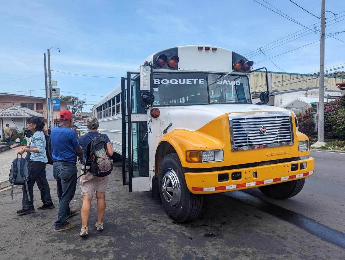 Żółty autobus z napisami Boquete i David na przystanku w Bajo Boquete