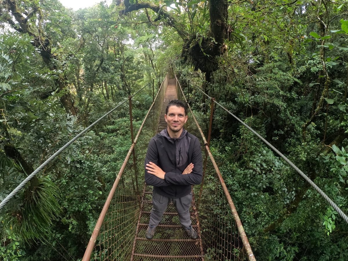 Na środku wiszącego mostu z siatkowymi barierkami w lesie Boquete Tree Trek