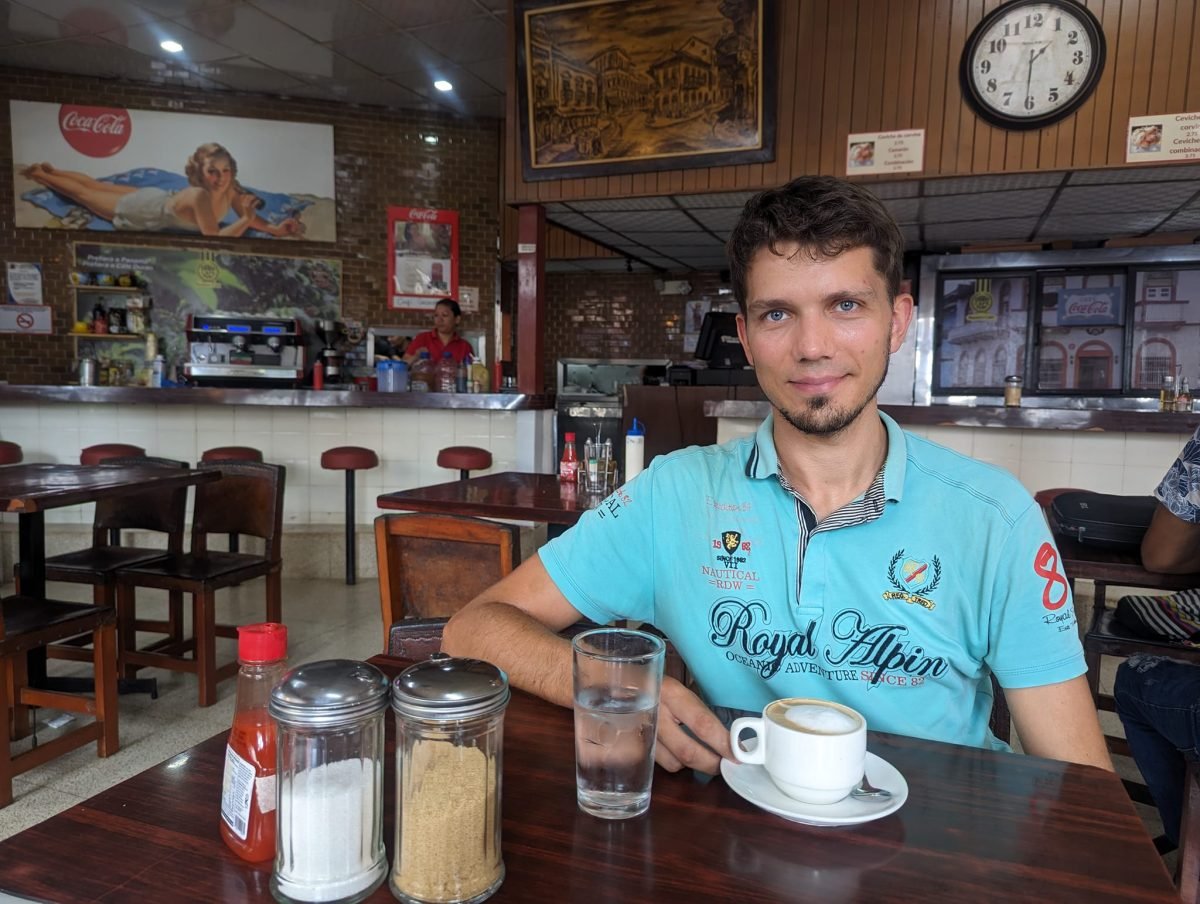 Przy stoliku z filiżanką kawy z mlekiem we wnętrzu Café Coca-Cola
