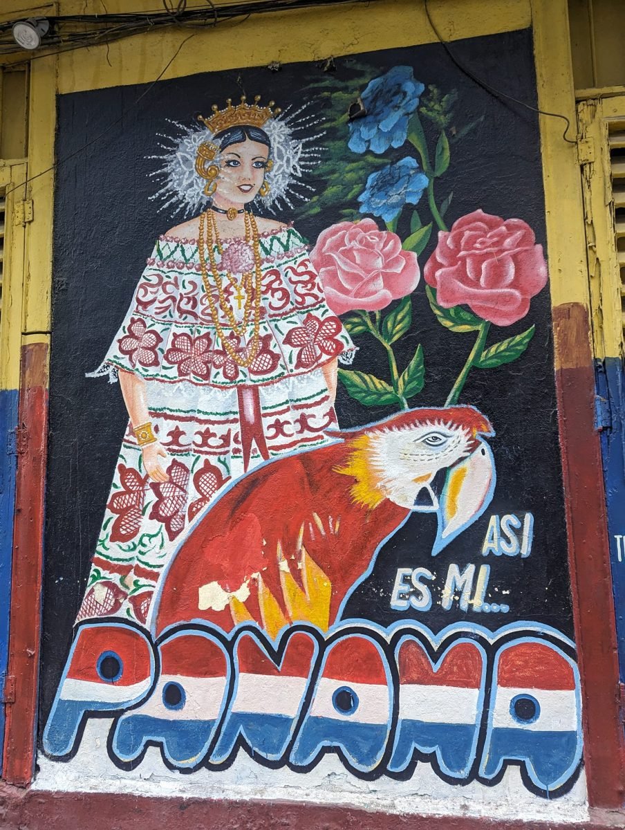 Mural z kobietą w tradycyjnym stroju pollera, papugą ara i napisem Así es mi Panamá