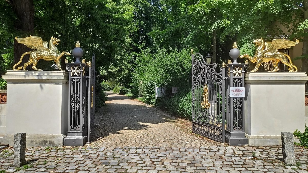 Brama ze złotymi gryfami przy wejściu do parku pałacowego Glienicke w berlińskiej dzielnicy Wannsee