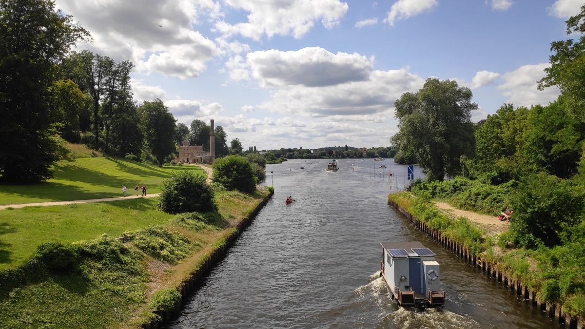 Wąski kanał z łodzią i zielonymi brzegami w okolicy jeziora Griebnitzsee