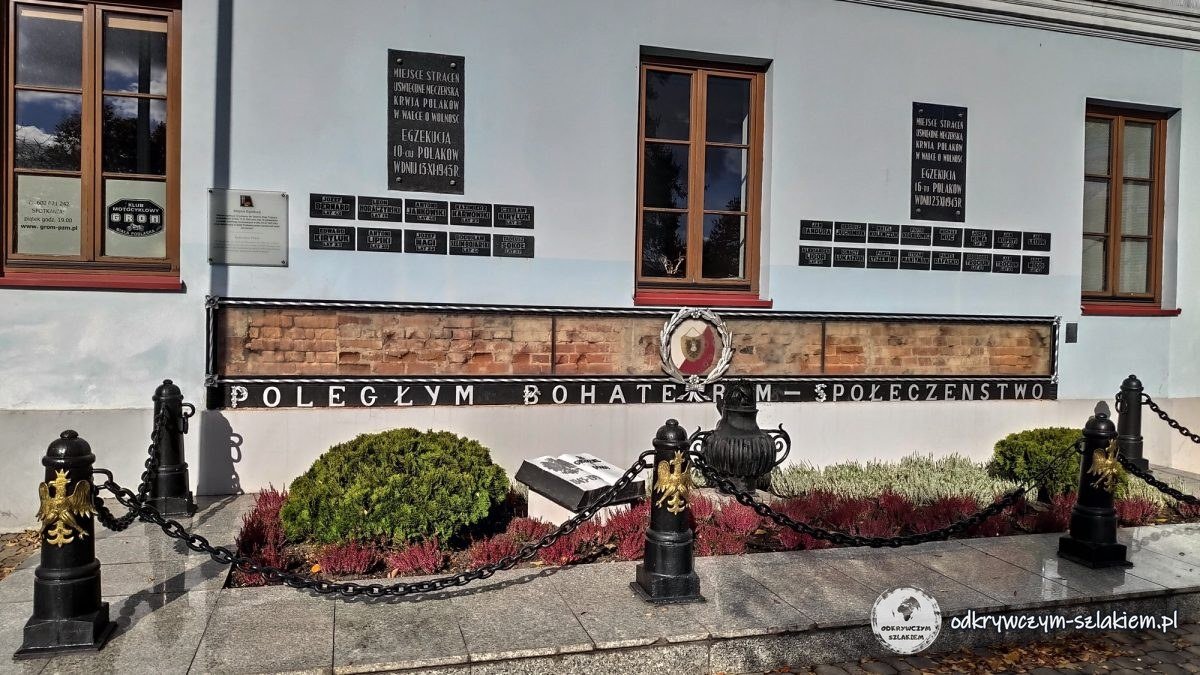 Das Denkmal „Den gefallenen Helden“ und Gedenktafeln an der Wand eines Gebäudes am Freiheitsplatz in Biała Podlaska