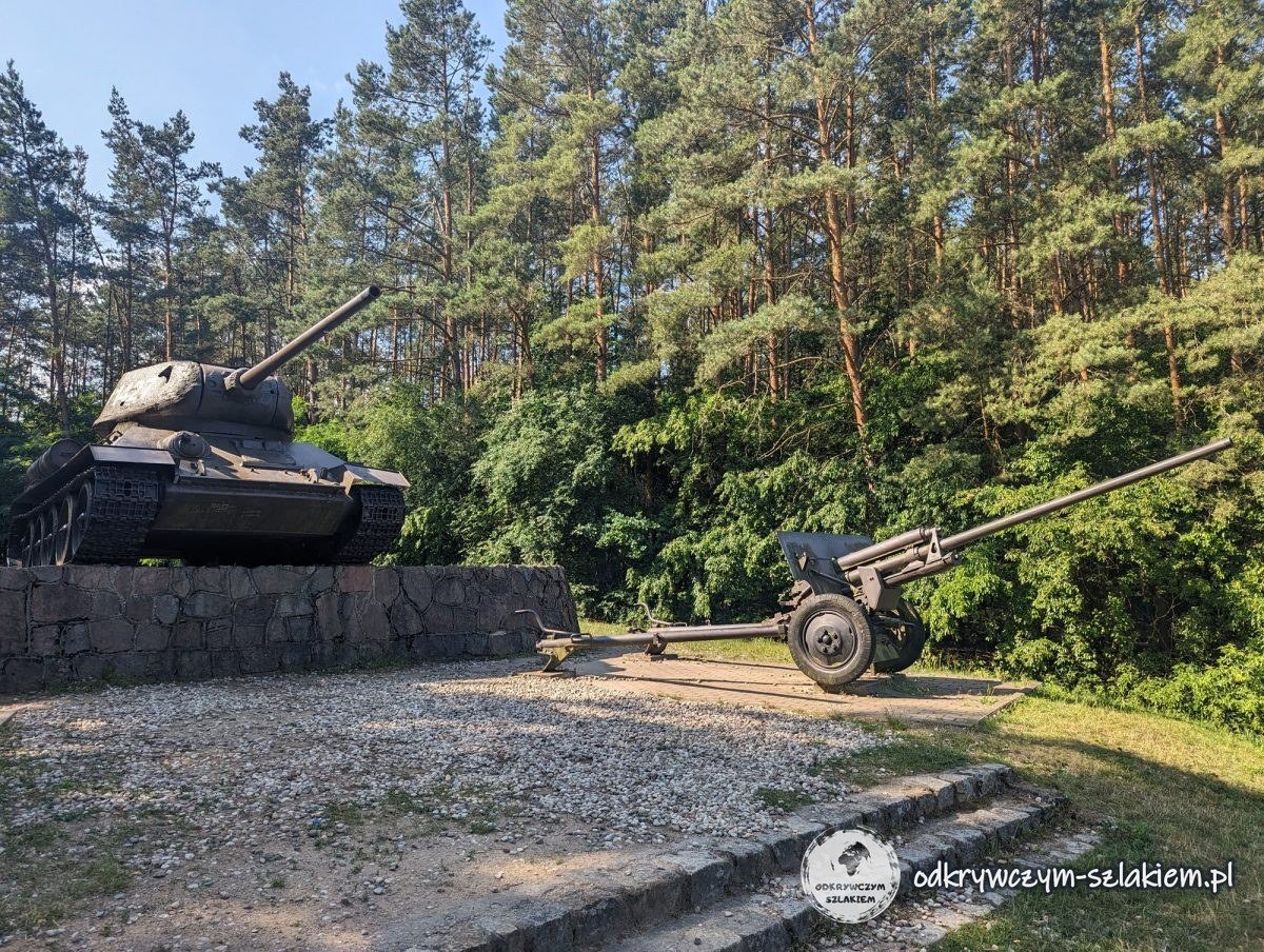 Denkmal mit einem T-34-Panzer und Geschützen zwischen Kiefern in Nowogród