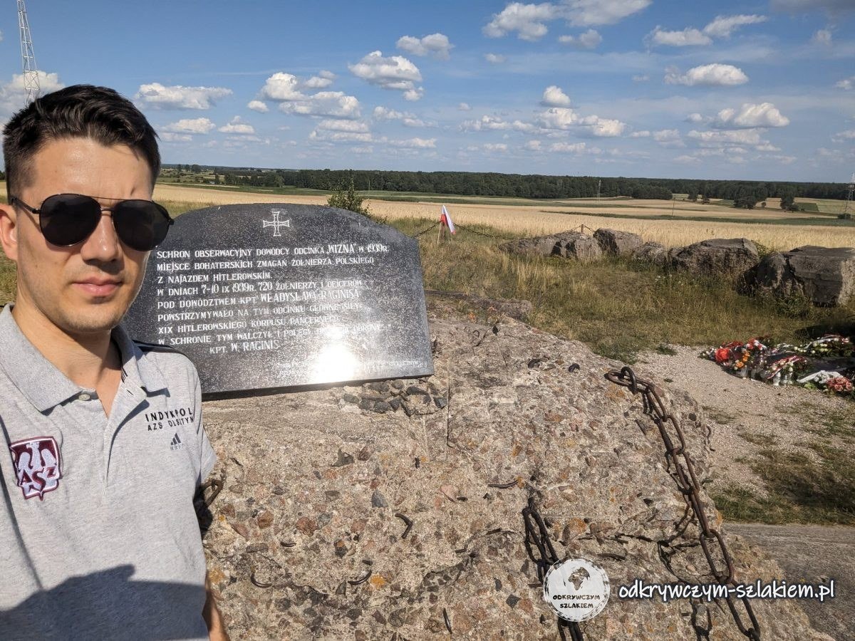 Maciek mit Sonnenbrille an der Gedenktafel auf den Ruinen des Bunkers des Kommandeurs der Verteidigung von Wizna auf der Góra Strękowa
