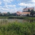 Panorama von Tykocin am Narew mit der barocken Dreifaltigkeitskirche und Häusern am Fluss