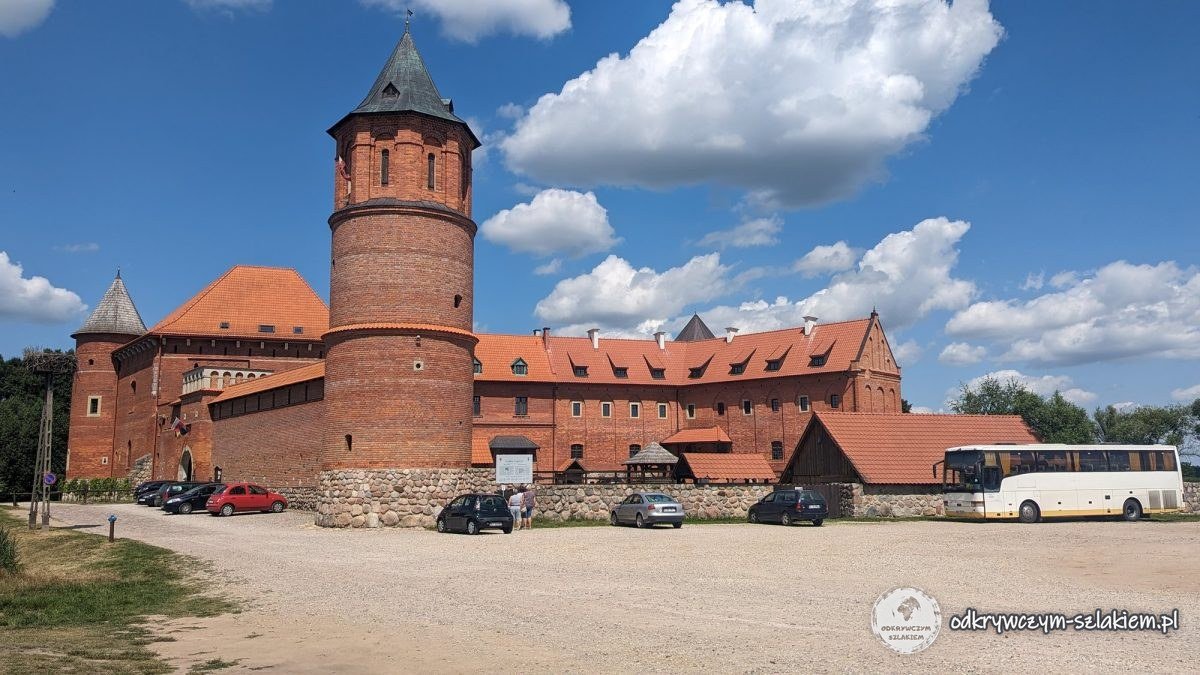 Die wiederaufgebaute Backsteinburg in Tykocin mit rundem Turm, vom Parkplatz aus gesehen