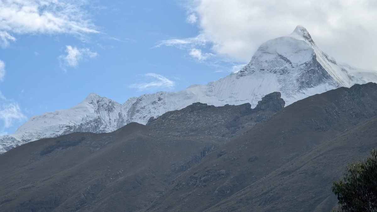 Ośnieżone szczyty Cordillera Blanca o poranku nad ciemnym grzbietem doliny