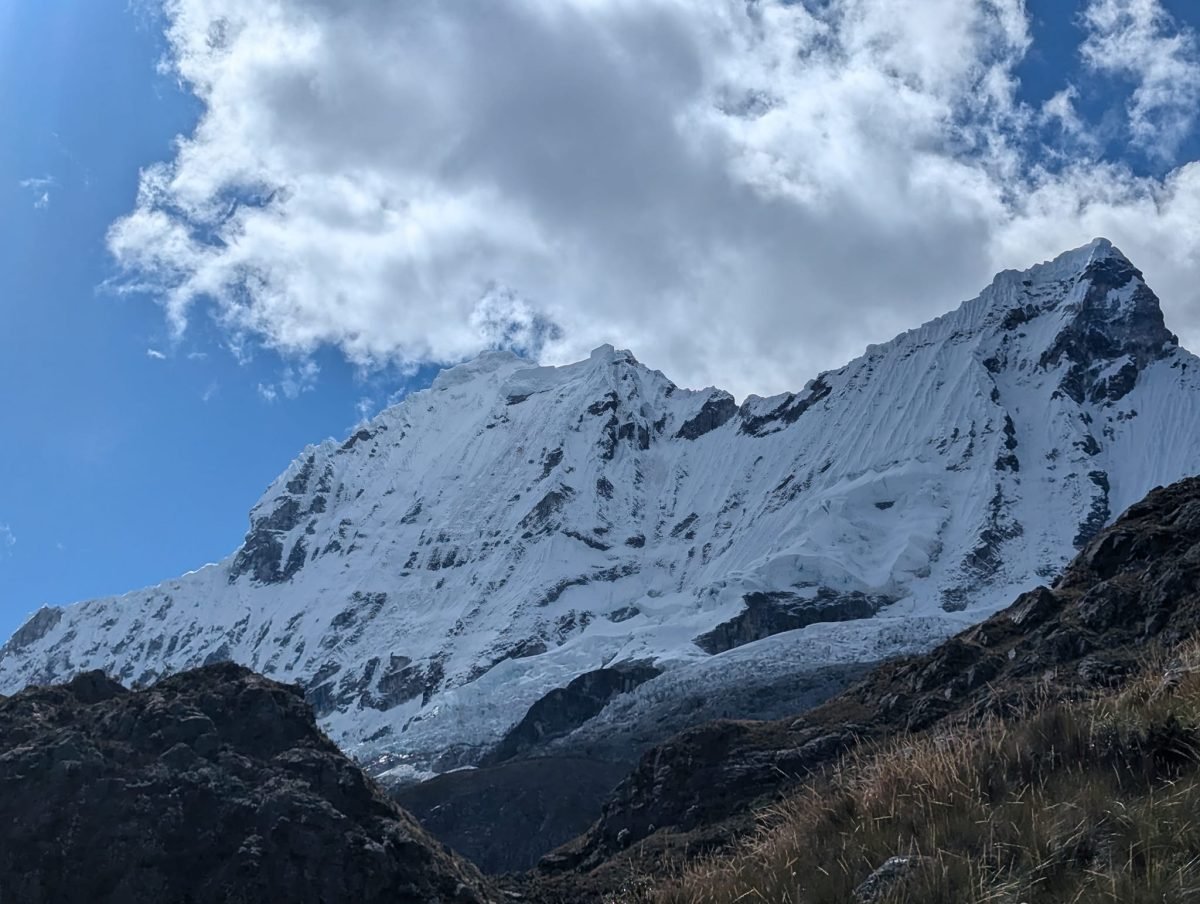 Ośnieżona ściana szczytu Cordillera Blanca na tle błękitnego nieba i chmur