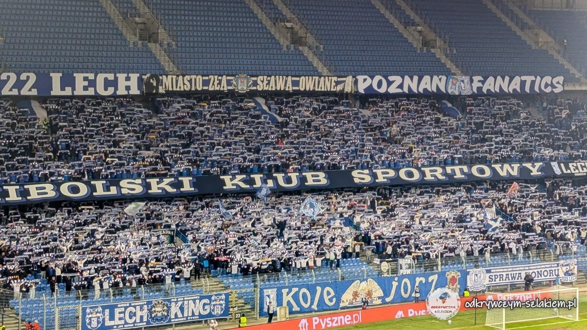 The Lech Poznań fans’ stand with scarves held up and banners during a Conference League match
