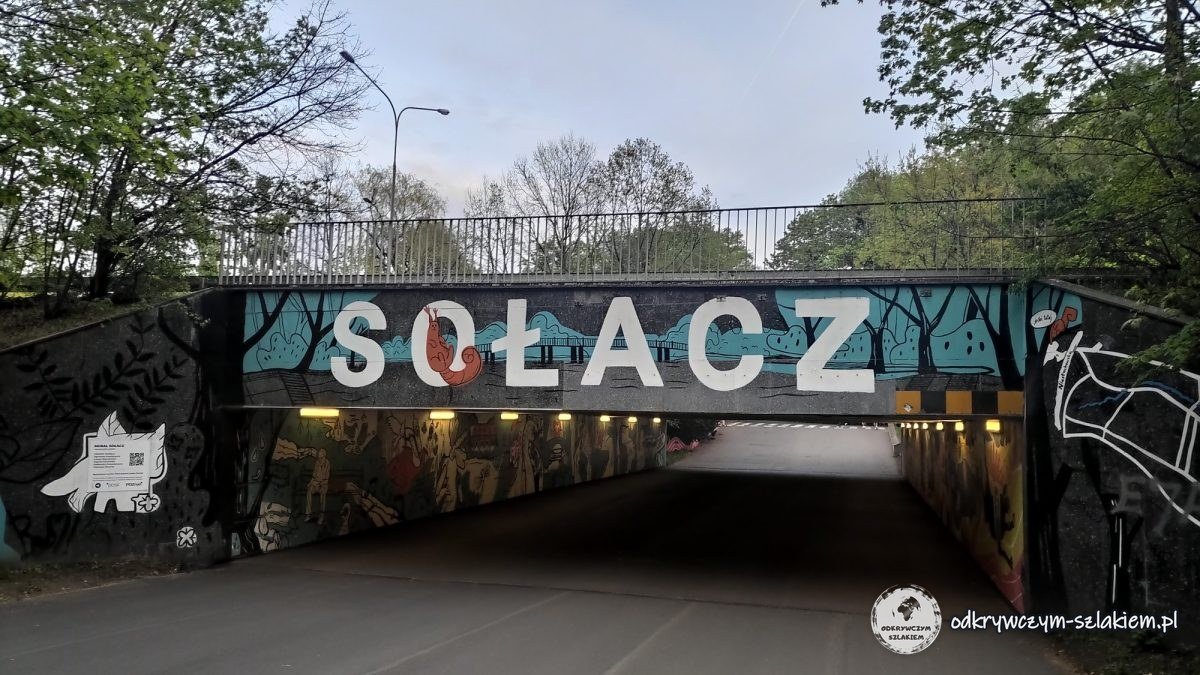 An underpass with a mural and a large SOŁACZ sign in Poznań