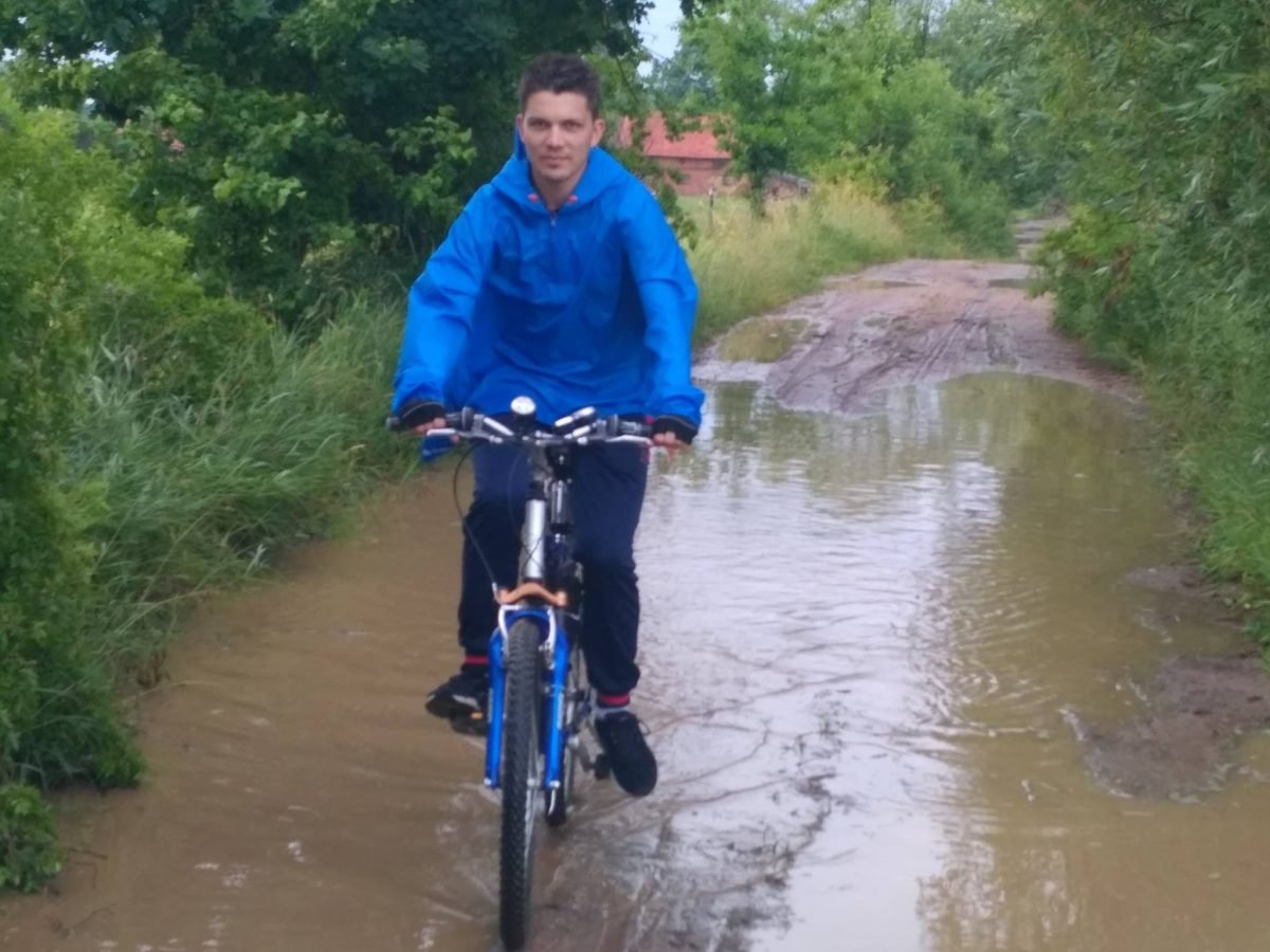 Przejazd rowerem przez zalaną drogę gruntową