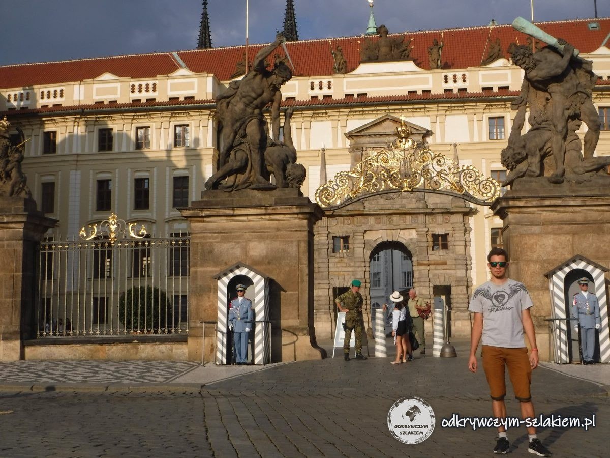 Maciek ante la puerta con esculturas de gigantes luchando y soldados de la Guardia del Castillo en Hradčany