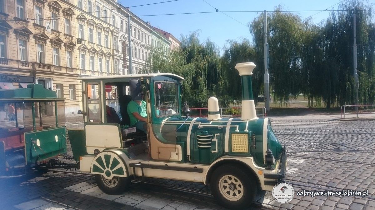 Un trenecito turístico verde con forma de locomotora de vapor en una calle de Praga