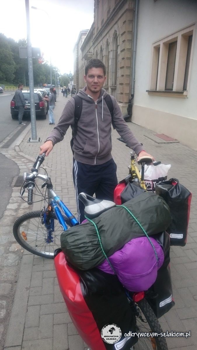 Maciek con su bici cargada de alforjas, tienda y saco de dormir en la acera junto a la estación de Jelenia Góra