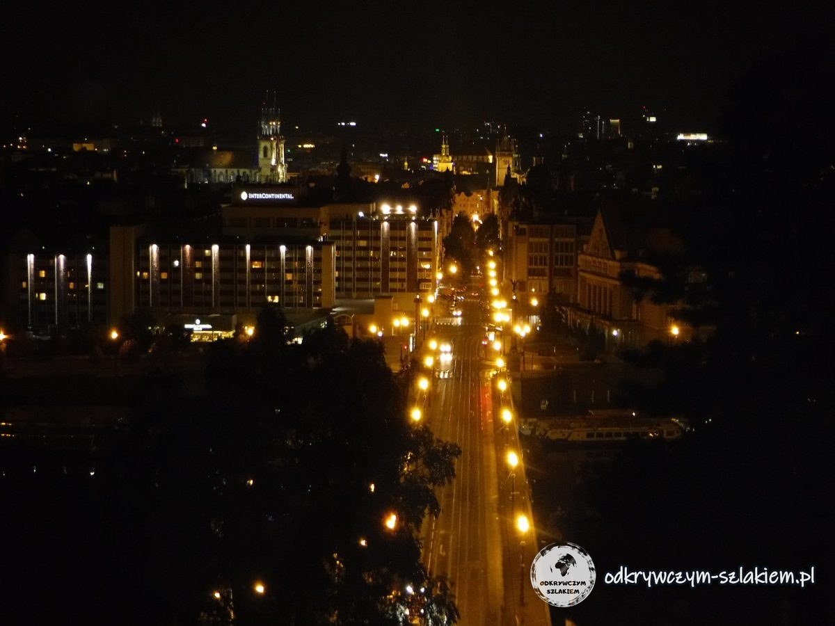 Panorámica nocturna de Praga desde Letná con un puente iluminado y una calle hacia la Ciudad Vieja