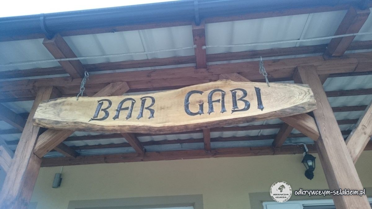 Drewniany szyld baru „Gabi” pod zadaszeniem w Starym Dzierzgoniu