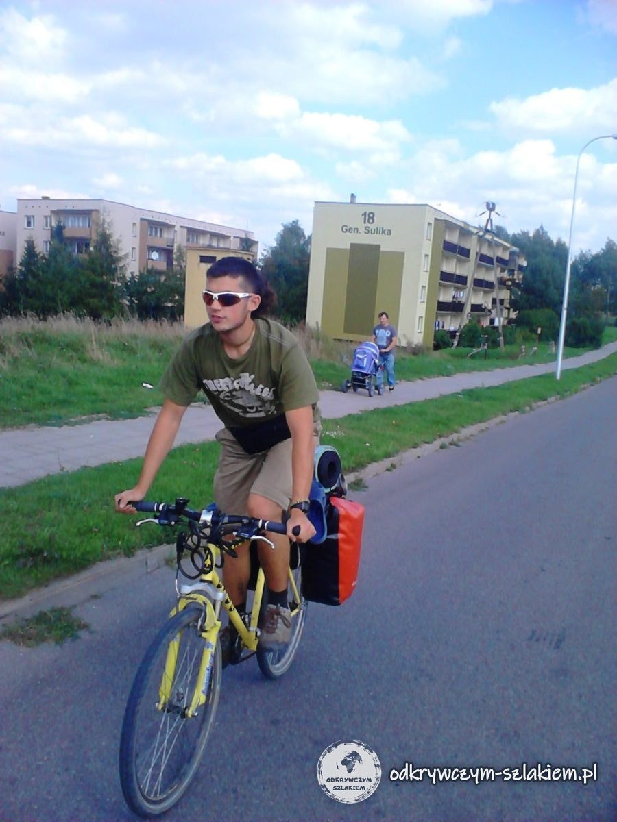Michał fährt auf seinem gelben beladenen Rad durch eine Siedlungsstraße in Dąbrowa Białostocka