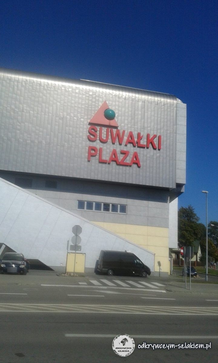 Das Einkaufszentrum Suwałki Plaza mit rotem Schriftzug an der silbernen Fassade