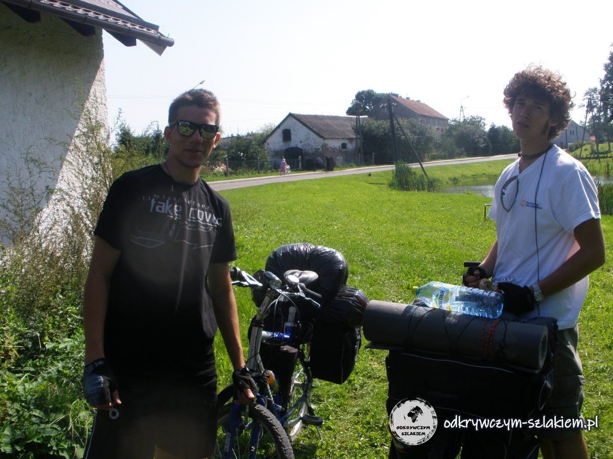 Zwei Radfahrer mit Packtaschen in einem Dorf zwischen Allenstein und Sensburg