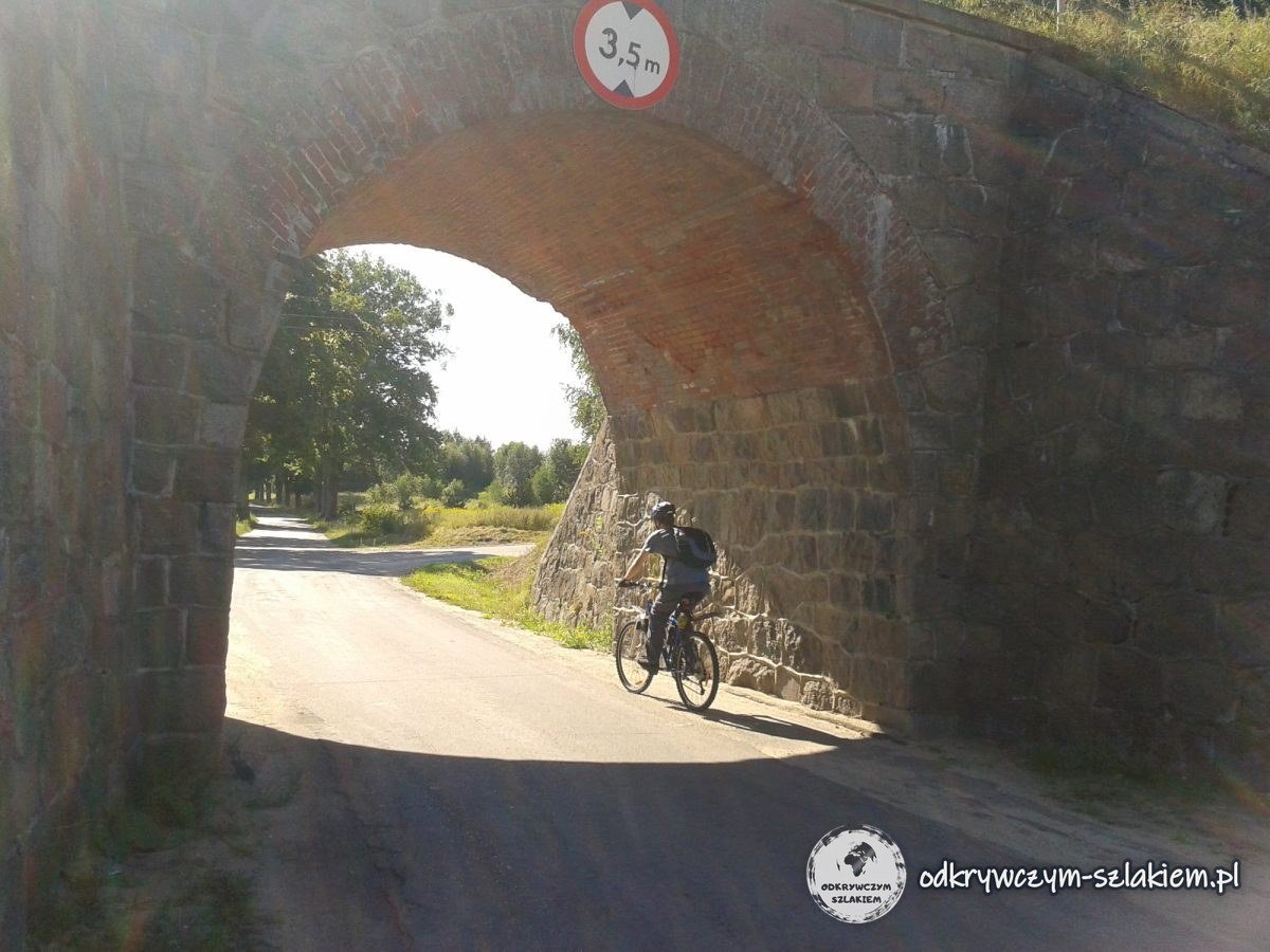 Ein Radfahrer fährt hinter Hohenstein unter einem gewölbten Eisenbahnviadukt hindurch