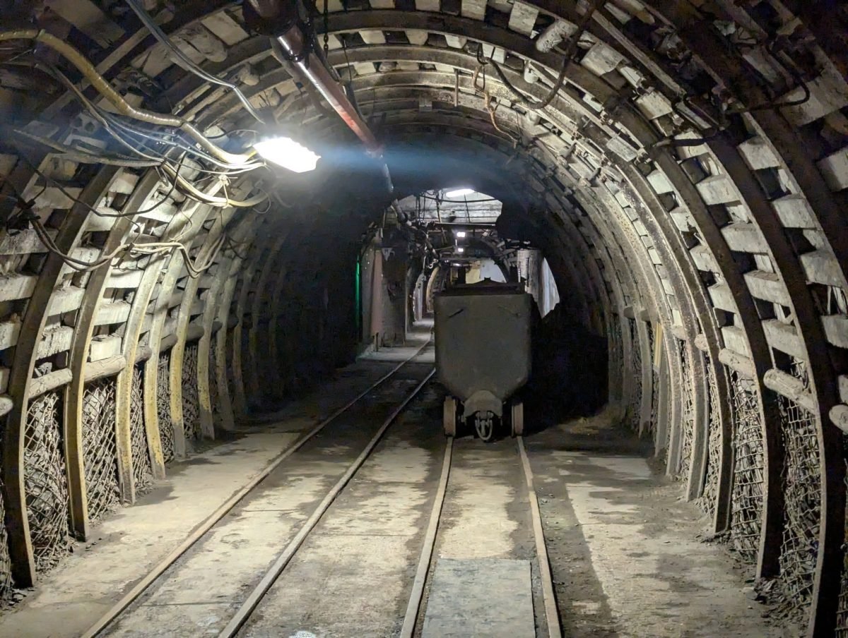 Chodnik w obudowie ze stalowych łuków z wózkiem górniczym na torach, 320 metrów pod ziemią w kopalni Guido