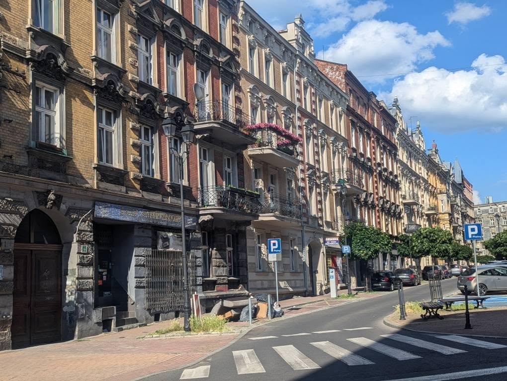 Zdobione kamienice przy ulicy w śródmieściu Katowic w słoneczne popołudnie
