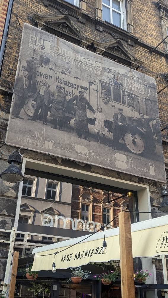 Wielka stara fotografia z ciężarówką browaru z Tychów na fasadzie kamienicy w centrum Katowic