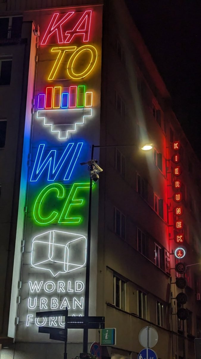 Kolorowy neon z napisem Katowice na fasadzie budynku w centrum miasta nocą