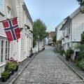 Białe drewniane domy i norweska flaga w Gamle Stavanger – starej części miasta