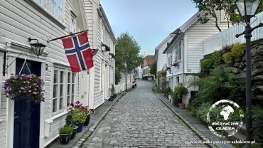 Białe drewniane domy i norweska flaga w Gamle Stavanger – starej części miasta