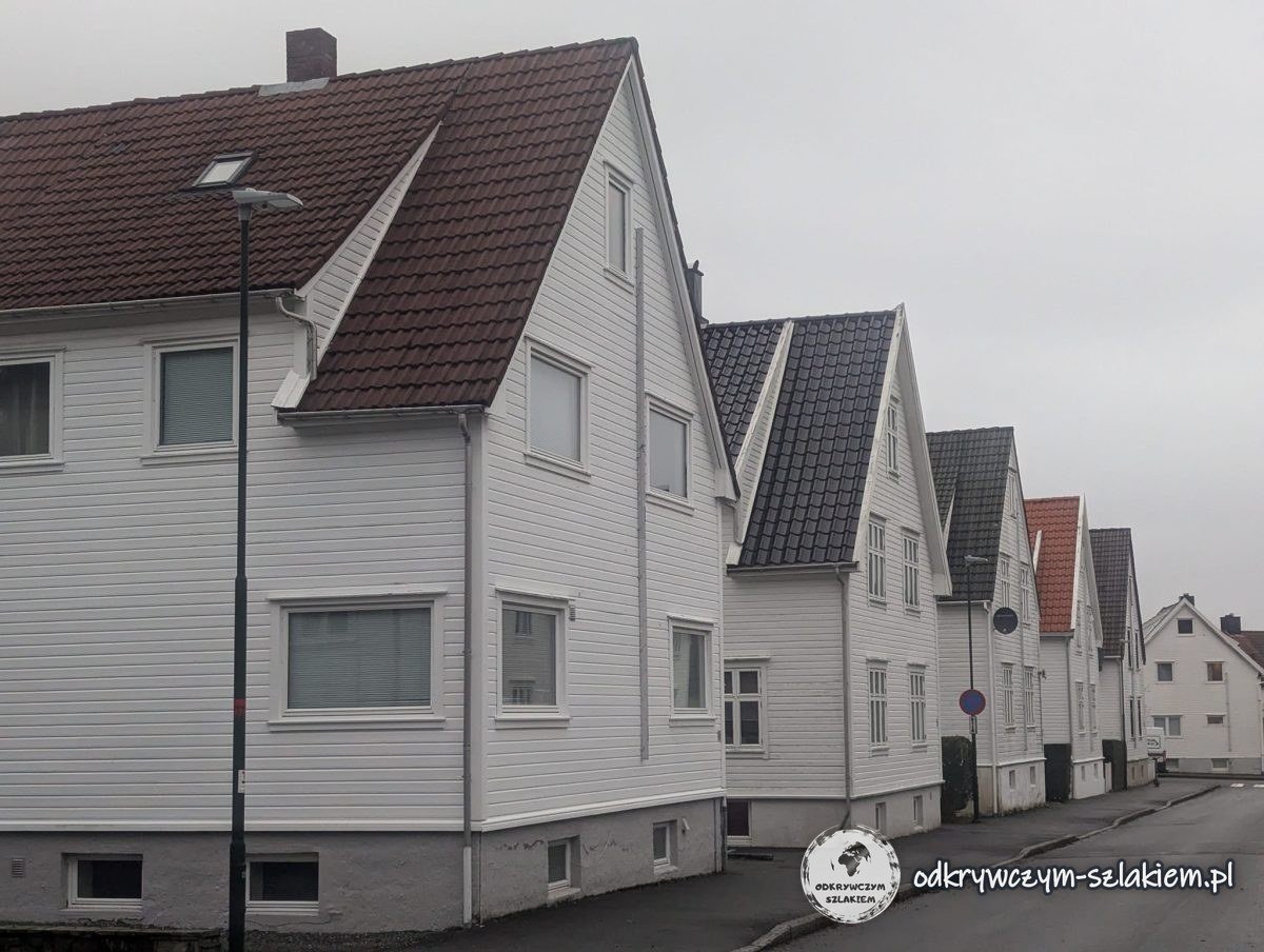 Rząd białych drewnianych domów przy ulicy w dzielnicy mieszkalnej Stavanger