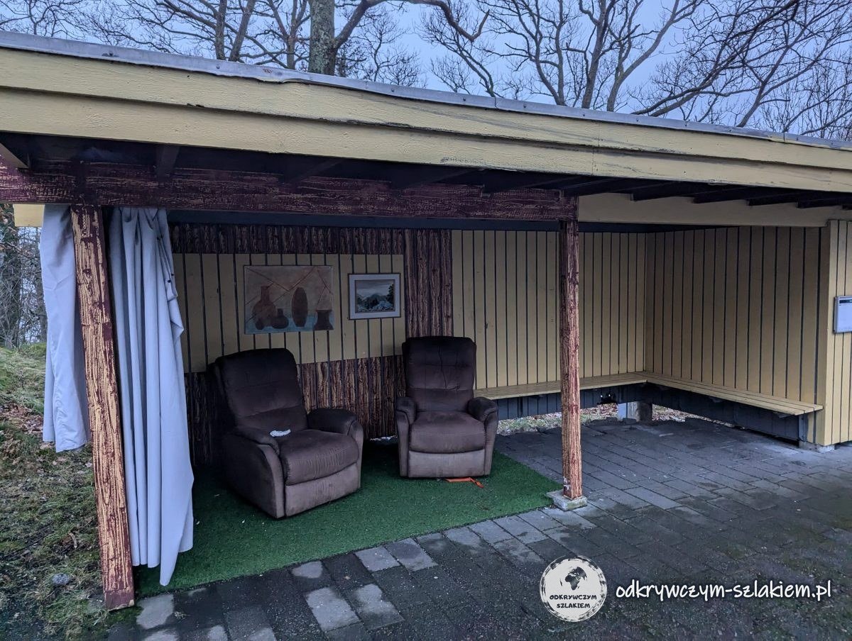 Wiata w Dale urządzona jak salon, z fotelami, zasłonami i obrazkami na ścianie
