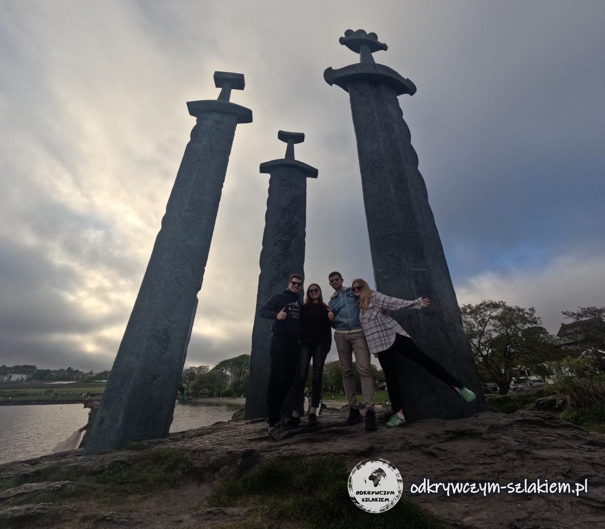 Cztery sylwetki pod mieczami Sverd i fjell nad Hafrsfjordem w majowym słońcu