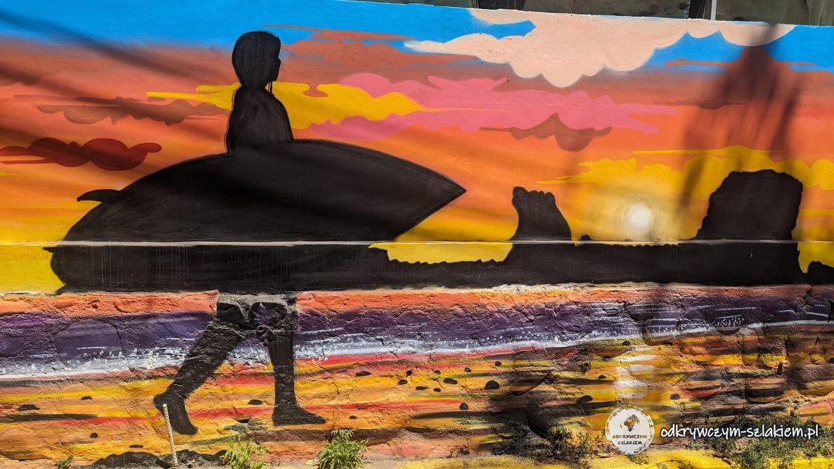 Mural z surferem i skałą El Tunco o zachodzie słońca