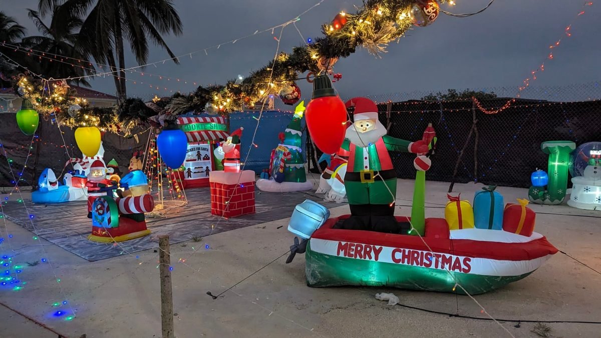 Dmuchany Mikołaj w łodzi z napisem „Merry Christmas” wieczorem