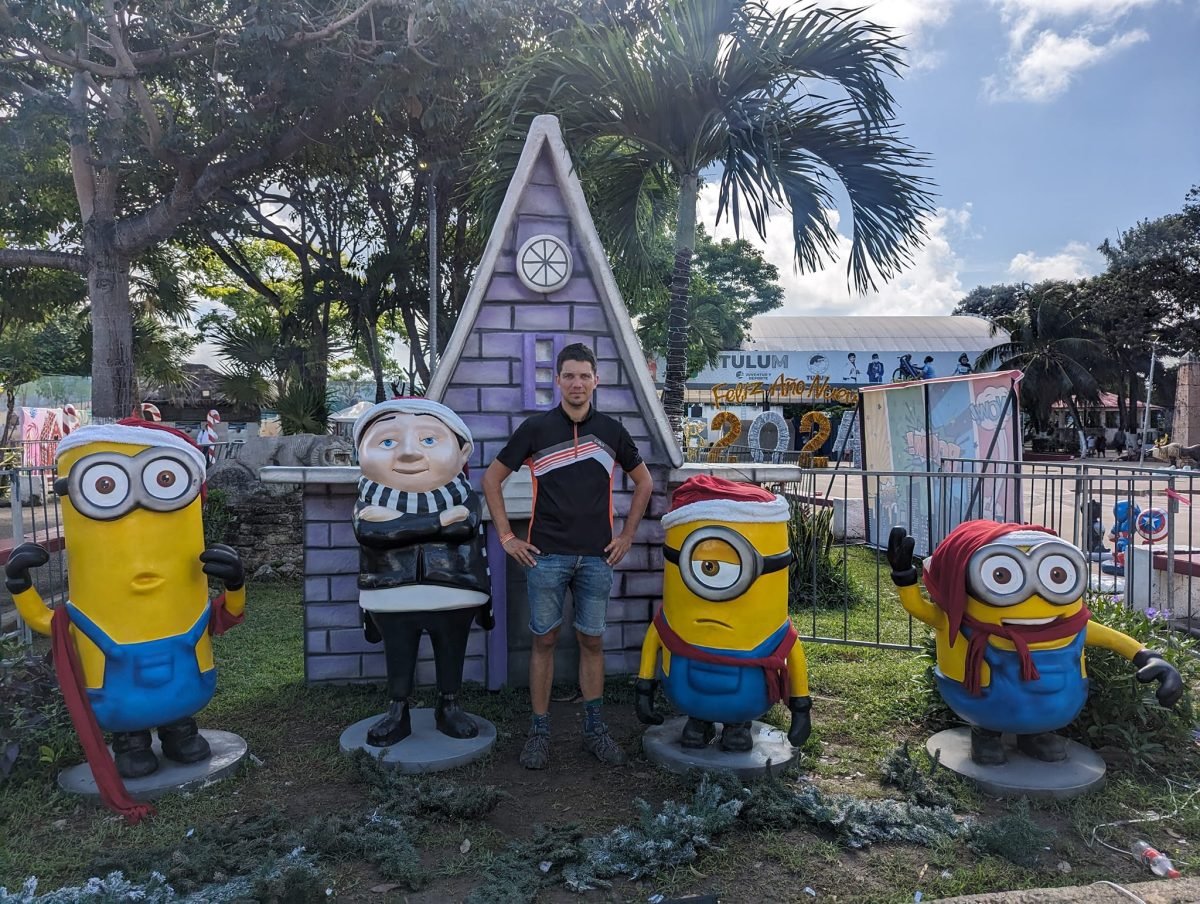 Figury Minionków w świątecznych czapkach przed domkiem z piernika