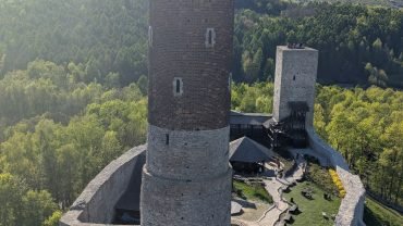Widok z wieży zamku w Chęcinach na drugą wieżę, dziedziniec i zalesione wzgórza
