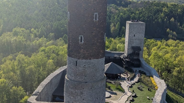 Widok z wieży zamku w Chęcinach na drugą wieżę, dziedziniec i zalesione wzgórza