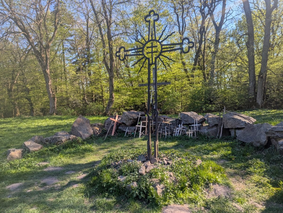 Metalowy krzyż wśród kamieni w lesie na Łysej Górze