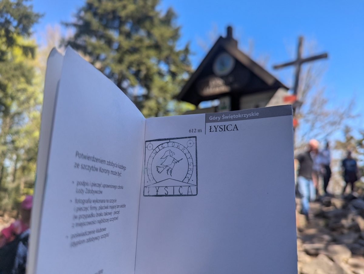 Pieczątka Łysicy w książeczce Korony Gór Polski, w tle krzyż na szczycie