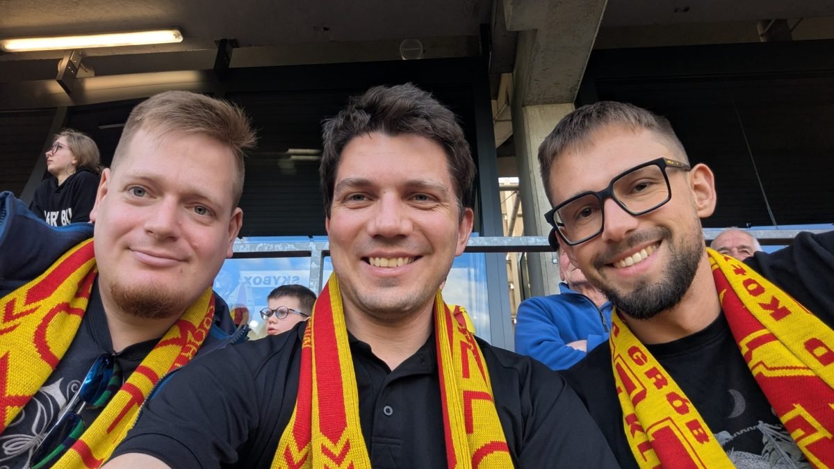 Maciek z Łukaszem i Mateuszem w szalikach Korony Kielce na trybunie stadionu