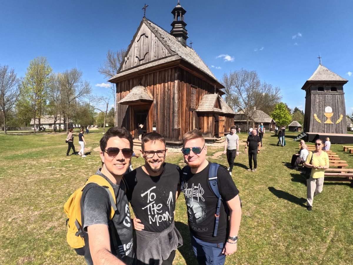Maciek z Łukaszem i Mateuszem przed drewnianym kościołem w skansenie w Tokarni