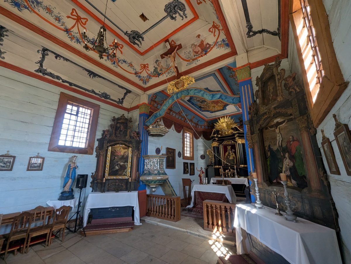 Malowany strop i barokowe ołtarze we wnętrzu drewnianego kościoła w skansenie w Tokarni