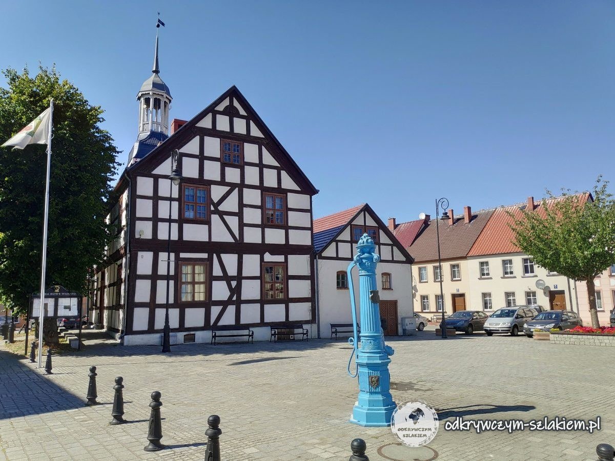 Ayuntamiento de entramado de madera de 1697 en la plaza de Nowe Warpno, al lado una bomba azul
