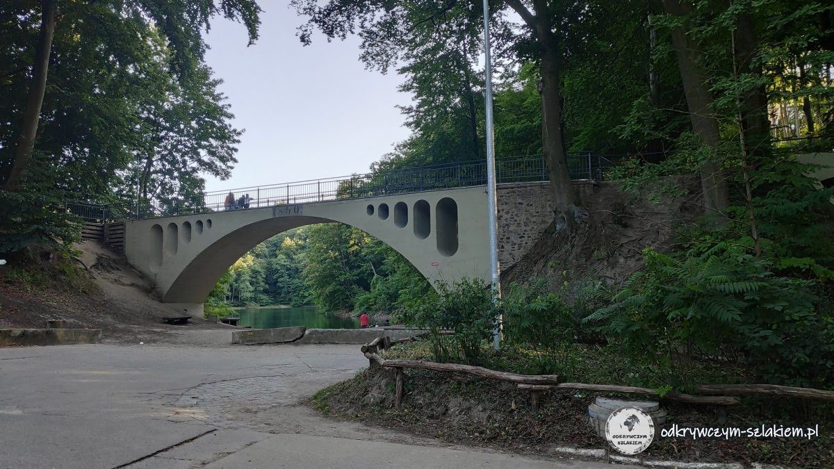 Puente de arco de hormigón sobre la vía del antiguo tren minero junto al Lago Esmeralda, en Zdroje