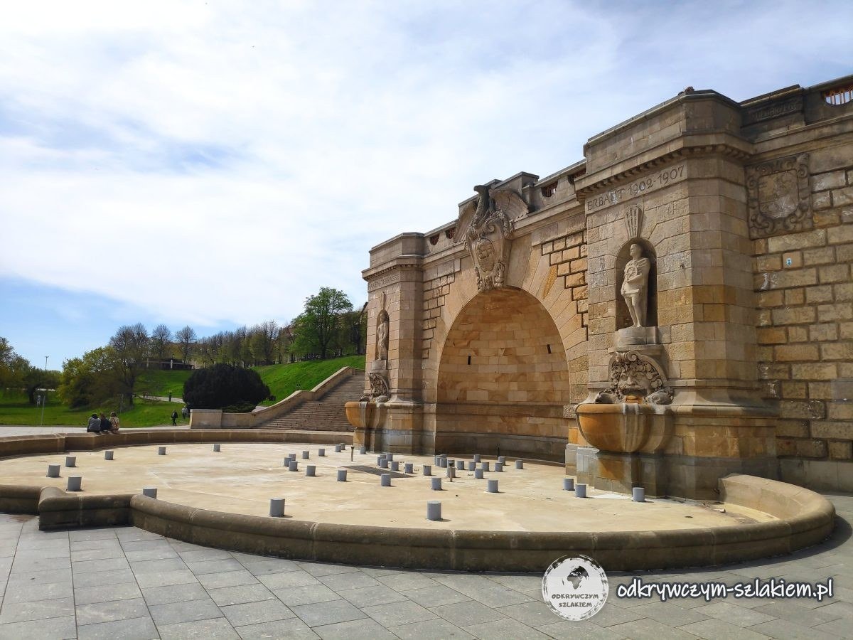 Fuente ante un nicho semicircular con estatuas en el muro de contención de las Terrazas de Chrobry