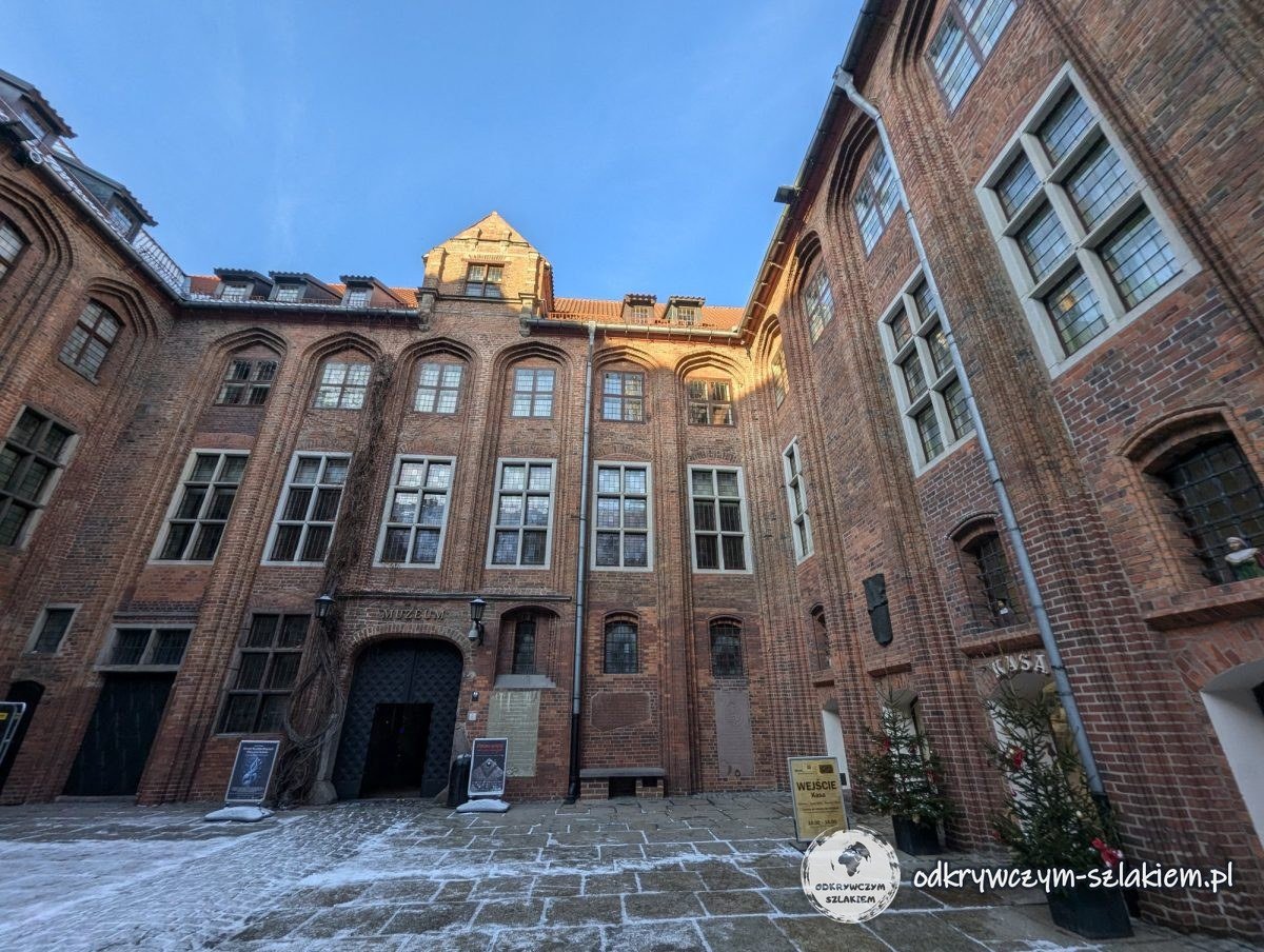 Patio de ladrillo del Ayuntamiento Viejo de Toruń con restos de nieve